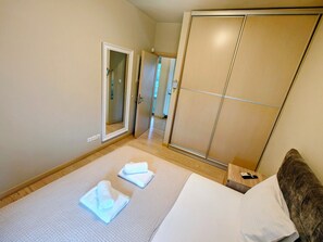 A hotel room with a bed, a wardrobe, and a mirror. - Serene,  spacious 4-bedroom villa in beautiful Pelion, located on the west side (Artemis)