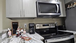 Une cuisine équipée d’un four à micro-ondes, d’une cuisinière et d’une machine à café.