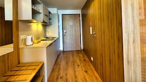 A narrow hallway with wooden flooring, a sink, and cabinets. - Warszawa, Wolska 2-3 osobowy apartament z klimatyzacją (Warszawa)