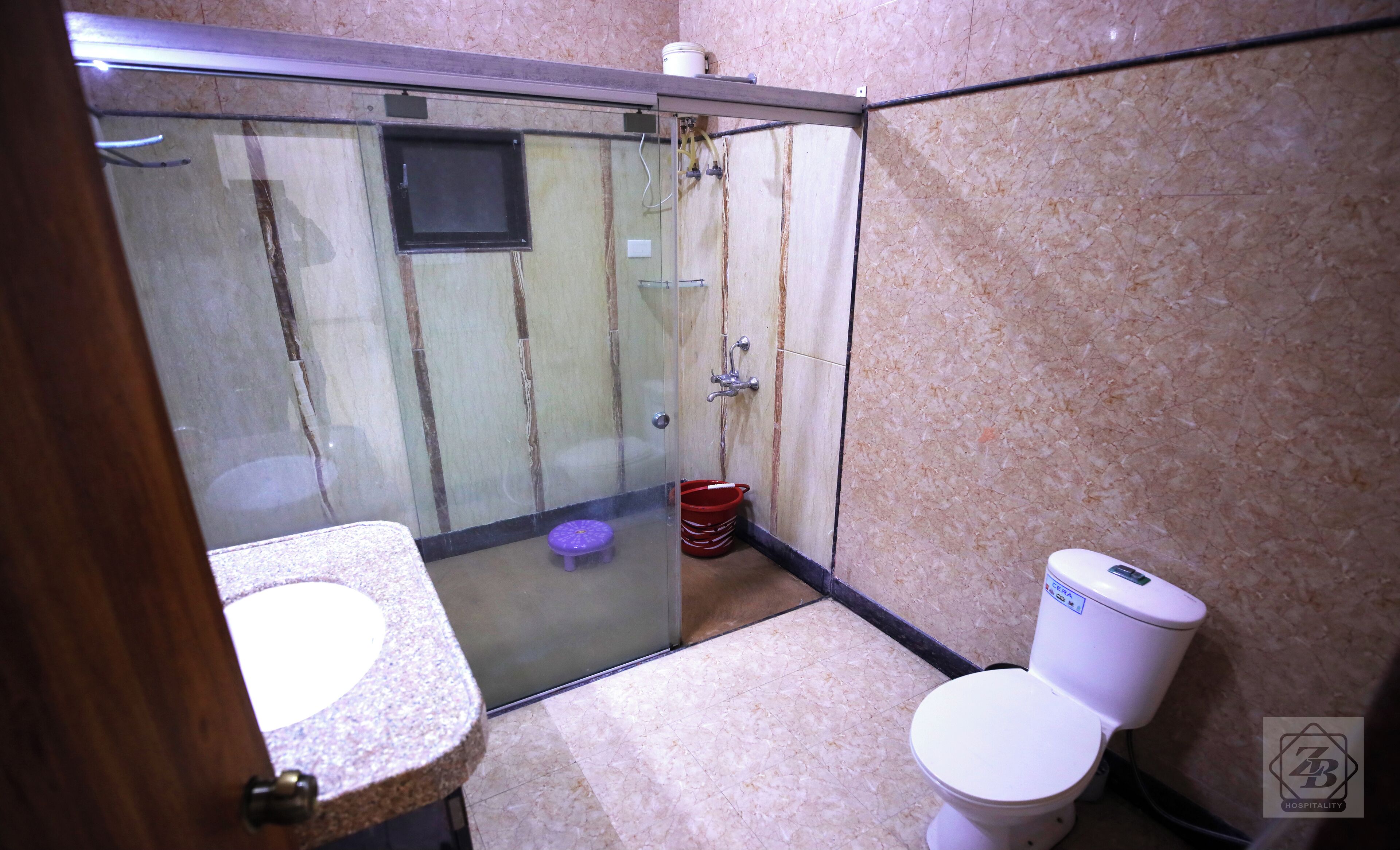 Un baño con ducha de vidrio, inodoro y lavabo.