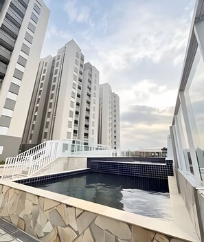 A modern building with a swimming pool, high-rise residential buildings, and a clear sky. - Benno Prime Loft (Extrema)