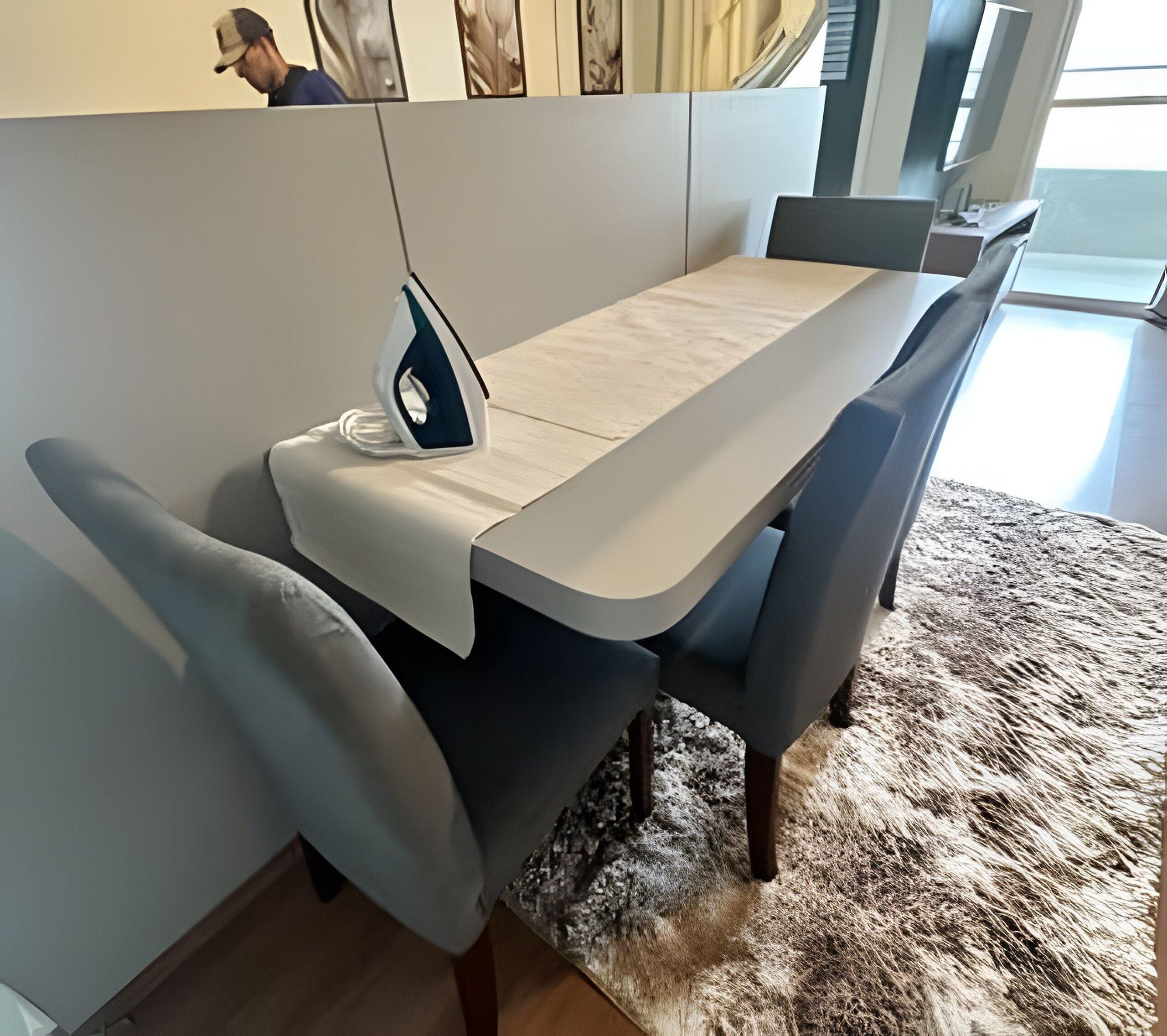 Un espace repas comprenant une table, des chaises et un fer à repasser.