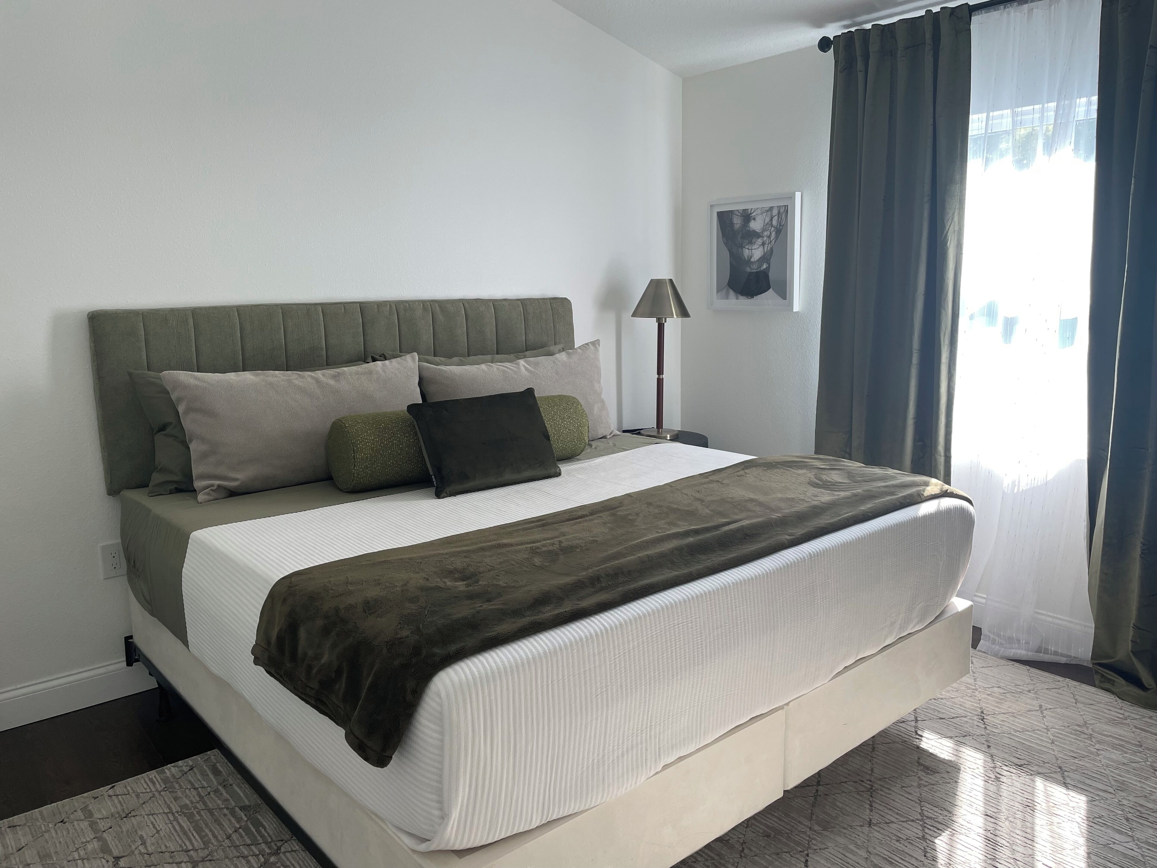 A neatly made bed with a headboard, pillows, and a blanket.