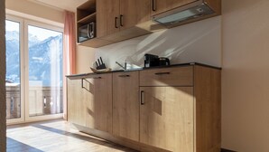 A kitchen with wooden cabinets, a microwave, and a coffee maker. - Pitztal Living (Jerzens)