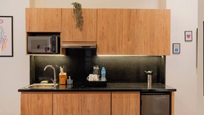 Une cuisine moderne avec des meubles en bois, un four à micro-ondes encastré, une machine à café et un lave-vaisselle.