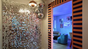 A room with a disco ball, a neon sign, and a blue sofa. - Paillettes fever, house with karaoke, 3 bedrooms (Croix)