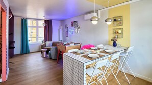 A modern kitchen with a tiled island, white chairs, and a neon sign. - Paillettes fever, house with karaoke, 3 bedrooms (Croix)