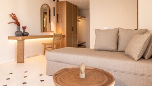 Ein modernes Wohnzimmer mit einer Couch, einem Holztischchen, einem Sessel und einem kleinen Tisch mit einer Dekoration.