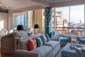 A modern living room with a sofa, armchairs, and a coffee table. There is a large window with a view of the city skyline. - Zamalek suuny khan (Cairo Governorate)