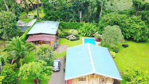 Une vue aérienne d’une propriété comprenant une grande maison, une piscine et une végétation luxuriante.