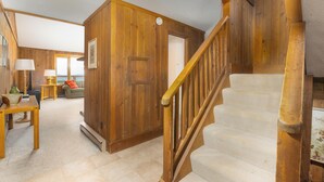 Un interior de madera con una escalera, un sofá y una mesa.