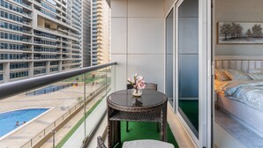 Ein Balkon mit Blick auf einen Swimmingpool und hohe Gebäude.