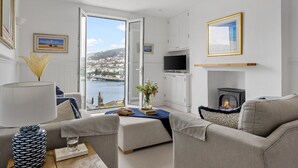 En moderne stue med sofa, sofabord, pejs og fjernsyn.