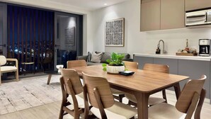 A modern kitchen with a dining area, a coffee machine, and a large window overlooking a cityscape. - Plaza Peninsula TJ Zona Dorada 3era Etapa Rio (Tijuana)