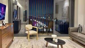 A modern living room with a large sliding glass door leading to a balcony with a city view. - Plaza Peninsula TJ Zona Dorada 3era Etapa Rio (Tijuana)