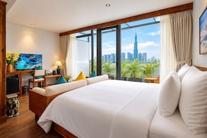 A hotel room with a large bed, a desk with a TV, and a view of a city skyline. - Nexus House Retreat Xuan Thuy (Ho Chi Minh City)