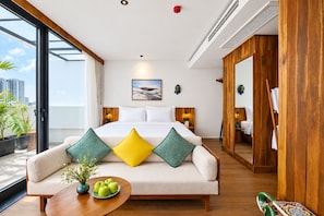 A modern hotel room with a large bed, a sofa, a small table with apples, and a city view. - Nexus House Retreat Xuan Thuy (Ho Chi Minh City)