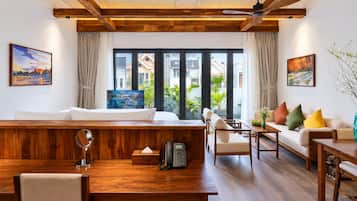A modern living room with a wooden ceiling, a sofa, a dining table, and a view of the outside.