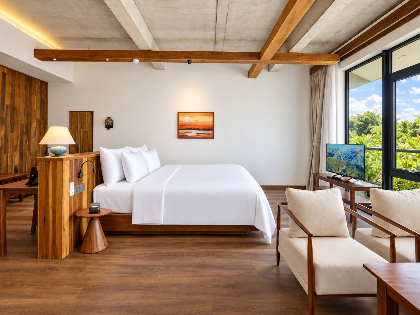 A modern hotel room with a large bed, wooden furniture, a television, and a window with a view of greenery.