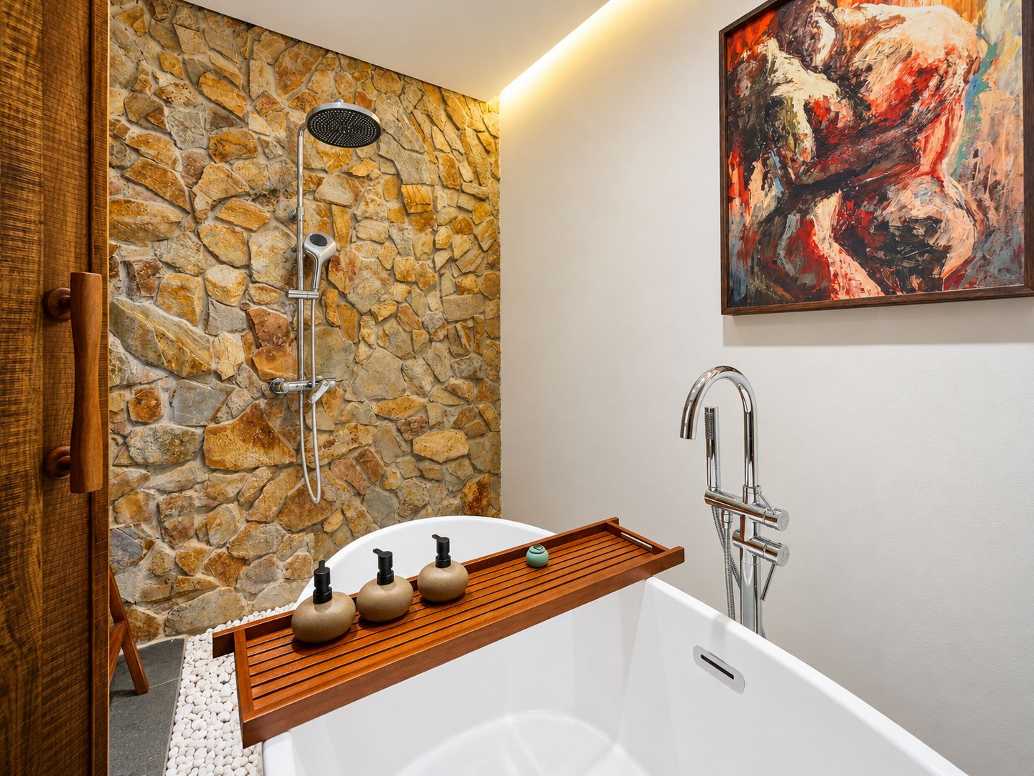 A bathroom with a stone wall, a shower, a bathtub, and a wooden shelf with toiletries.