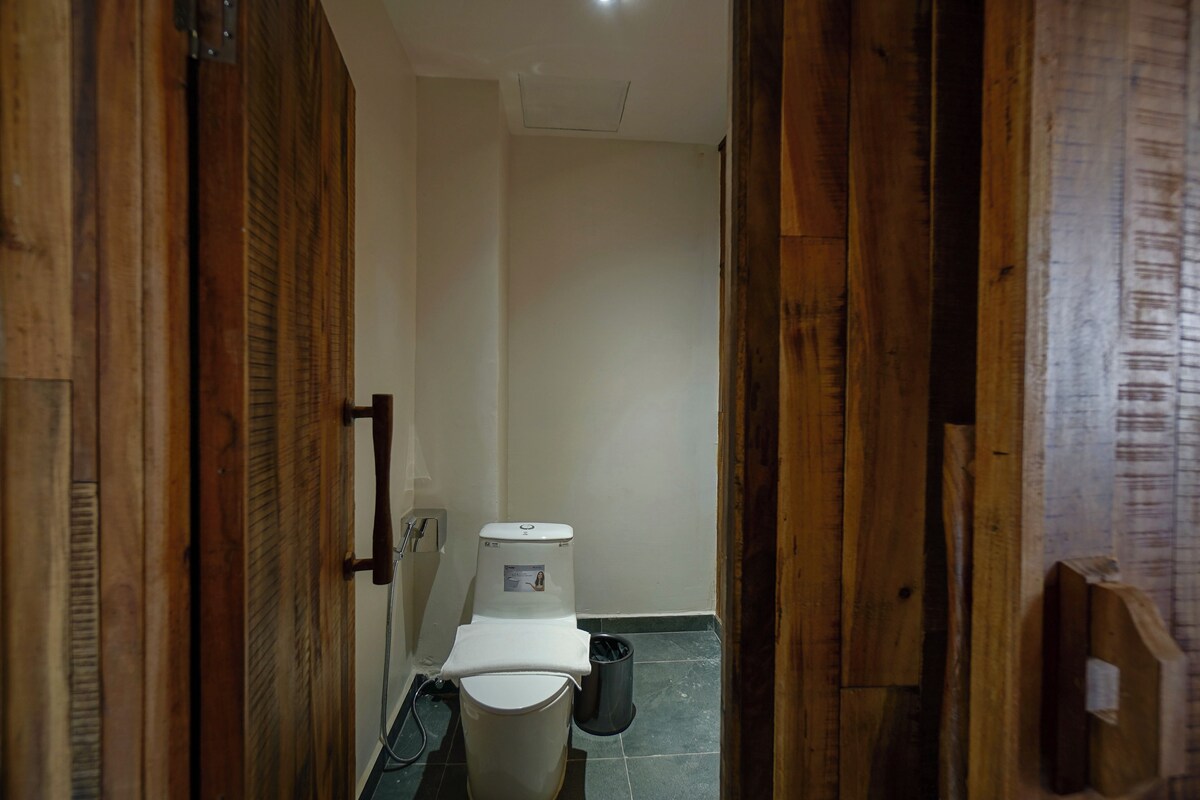 A narrow hallway with wooden doors on either side leading to a bathroom.