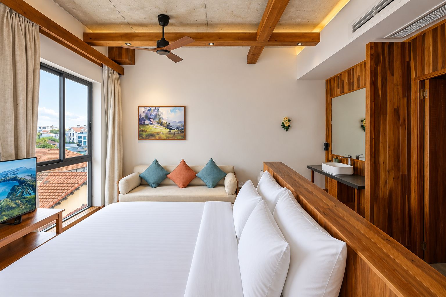 Een hotelkamer met een groot bed, een houten bankje, een televisie, een schilderij en uitzicht op buiten.