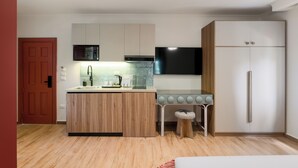 Eine moderne Küche mit einer Holztischinsel, einer eingebauten Mikrowelle, einem Herd und einem Kühlschrank.