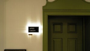 Eine grüne Tür mit einem Schild darüber, auf dem 'APRIL GREEN' steht.