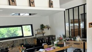 Una cocina moderna con una isla central, taburetes de bar y vistas al exterior.