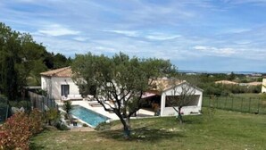 Una casa con piscina, un jardín pequeño y vistas al campo.