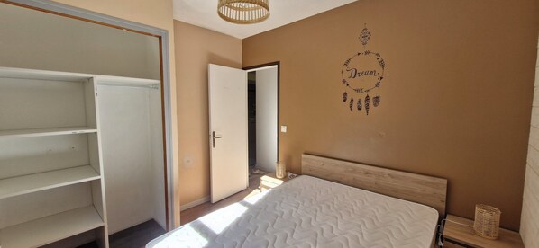 A bedroom with a bed, a wardrobe, and a wall with a 'Dream' decoration.