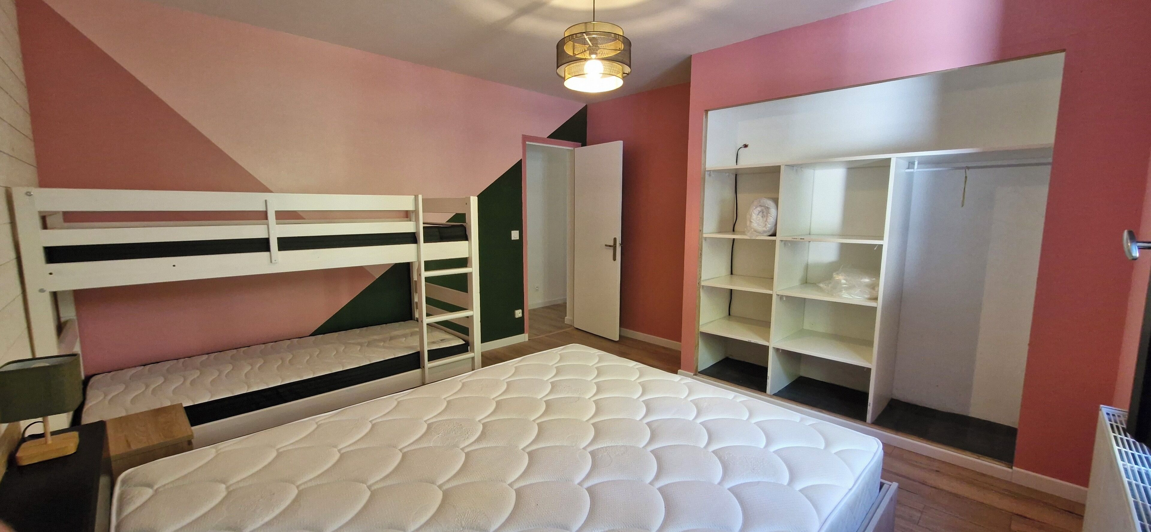 Quarto com beliches, guarda-roupa e mesa de cabeceira.