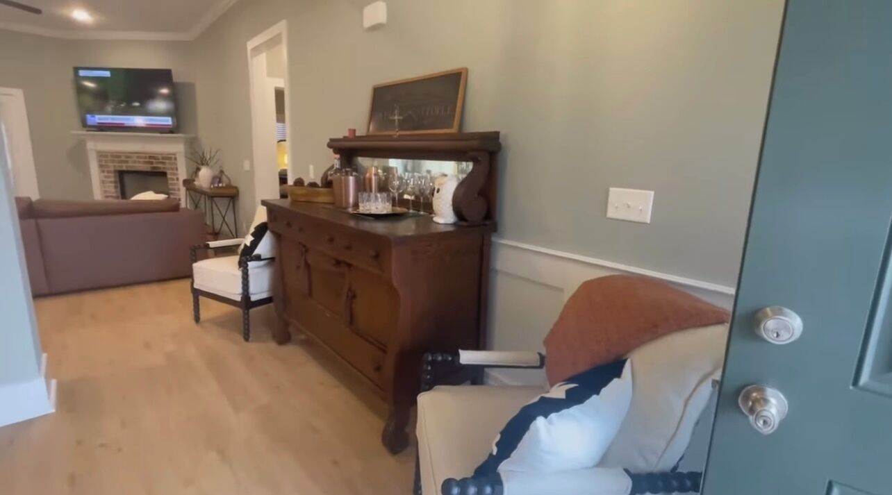Ein Wohnzimmer mit Kamin, Fernseher und Essbereich mit Holztisch und Stühlen.