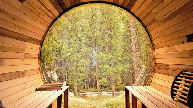 A wooden interior with a circular window leading to an outdoor forest view. - Keystone 5BD 5.5BT Luxury Remodel 2025 & Pets (Keystone)