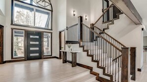 A spacious interior with a wooden staircase, large windows, and a modern design. - Keystone 5BD 5.5BT Luxury Remodel 2025 & Pets (Keystone)