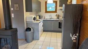 A compact kitchen with a stove, microwave, sink, and cabinets. - Cosy chalet 2-8pers/linen provided (Gérardmer)
