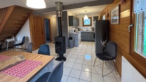 A cozy cabin interior with a dining area, kitchen, and a fireplace. - Cosy chalet 2-8pers/linen provided (Gérardmer)