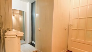 A room with a wooden parquet floor, white walls, and a white wardrobe with a mirrored door. - Vintage Loft in the center (Cluj-Napoca)