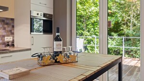 Una cocina moderna con una botella de vino y copas sobre una mesa.