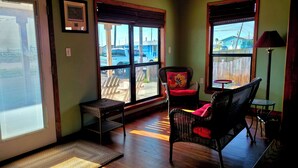 A room with a large window, wicker furniture, and a view of the outside. - Home, Hooks & Heart: Anglers Paradise Family-Friendly Bay House Marina 2 Blocks (Corpus Christi)