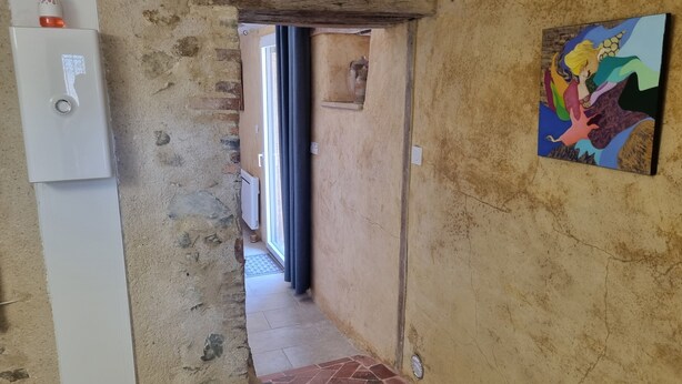 A hallway with a white door, a radiator, and a tiled floor. - Unique Vacation Rental: Le Boupère la Forestrie, Puy du Fou (Le Boupère)