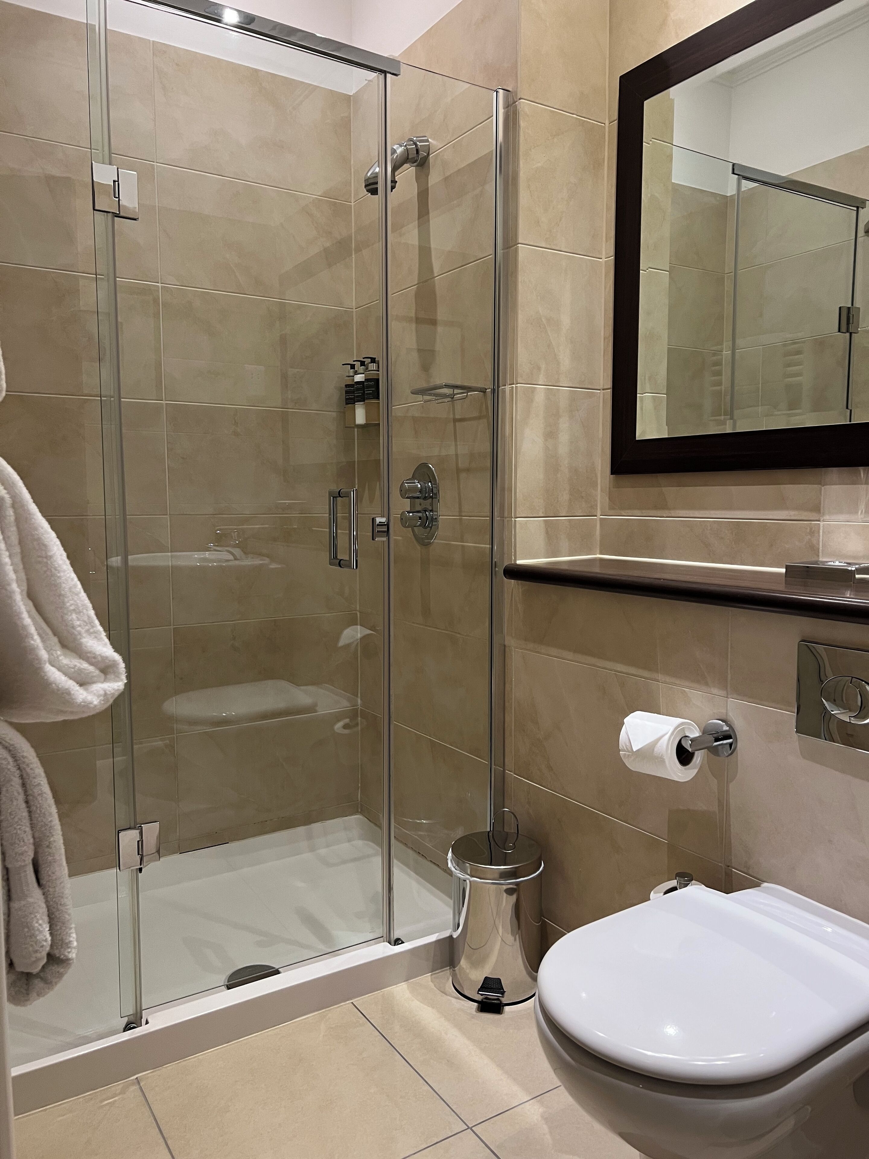 Une salle de bain moderne avec une douche à parois de verre, des toilettes et un lavabo.