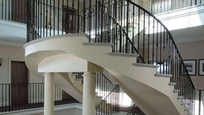 A multi-level interior with a central spiral staircase, wooden flooring, and a skylight.