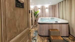 Ein Spa-Raum mit Holztür, Whirlpool und einer kleinen Holzbank.