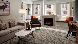 A living room with a sofa, armchair, fireplace, and large windows. - Marriott Summit Watch Resort - 1-bedroom resort in Park City near town ski lift (Park City)