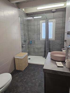 Une salle de bain moderne équipée d’une douche, de toilettes et d’un lavabo.