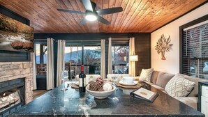 Una cocina moderna con encimera de mármol, chimenea empotrada y vistas al exterior.