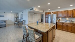 A modern kitchen with granite countertops, wooden cabinets, and stainless steel appliances. - Gorgeous Panoramic Views!  Stairs DIRECTLY to the beach!  PELICANS POINTE 5C (Indian Shores)