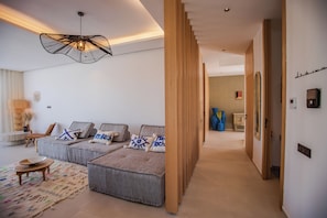 A modern living room with a sofa set, a patterned rug, and a unique pendant light. - Villa Marleanis (Marrakech)