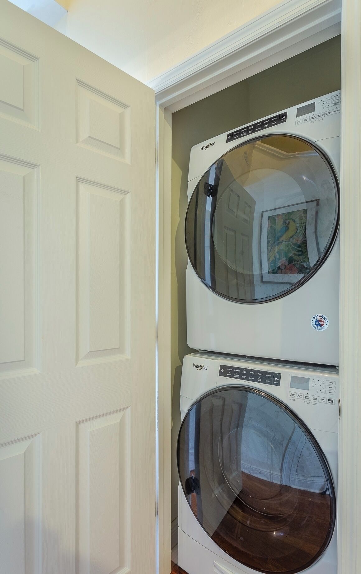Une buanderie équipée de deux machines à laver Whirlpool à chargement frontal, superposées.
